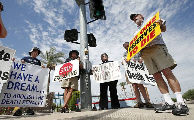 John Zemblidge, right, of Phoenix, leads a group of about a dozen death penalty opponents in prayer as they protest the possible execution of Joseph Rudolph Wood at the state prison in Florence, Ariz. on Wednesday, July 23, 2014. 
