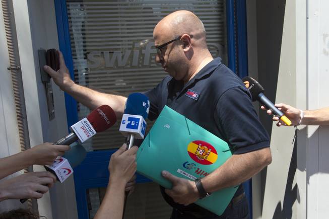 A man wearing a shirt with a Swiftair logo and carrying a Swiftair folder enters the Spanish airline's office in Madrid, Spain, Thursday, July 24, 2014. An Air Algerie flight carrying 116 people from Burkina Faso to Algeria's capital disappeared from radar early Thursday over northern Mali, officials said. The flight was being operated by Spanish airline Swiftair, the company said in a statement, and the plane belonged to Swiftair. The flight crew was Spanish. 