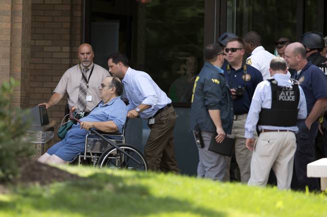 A patient is evacuated from the scene of a shooting at the Mercy Fitzgerald Hospital in Darby, Pa. on Thursday, July 24, 2014. A prosecutor said a gunman opened fire inside the psychiatric unit leaving one hospital employee dead and a second injured before being critically wounded himself.