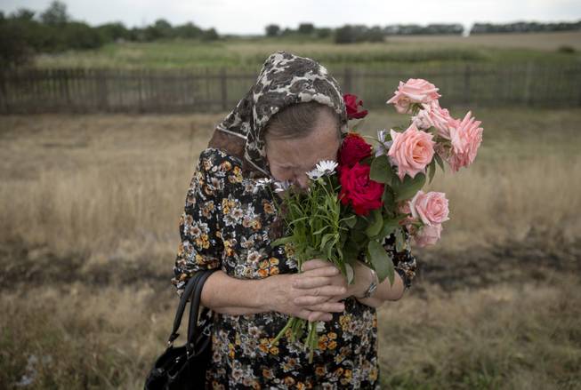 AP10ThingsToSee - A woman cries during a religious service held by villagers in memory of the victims at the crash site of Malaysia Airlines Flight 17, near the village of Hrabove, eastern Ukraine, Tuesday, July 22, 2014. 