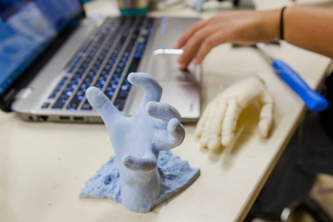 A mold of 4-year-old Hailey Dawson's left hand sits next to the prototype Robohand as Katherine Lau works on the design July 23, 2014 at the University of Nevada, Las Vegas. 