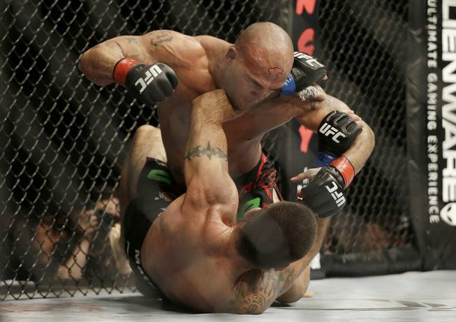 Robbie Lawler, top, punches Matt Brown during the fourth round of a welterweight mixed martial arts bout at a UFC event in San Jose, Calif., Saturday, July 26, 2014. Lawler won by unanimous decision. (AP Photo/Jeff Chiu)