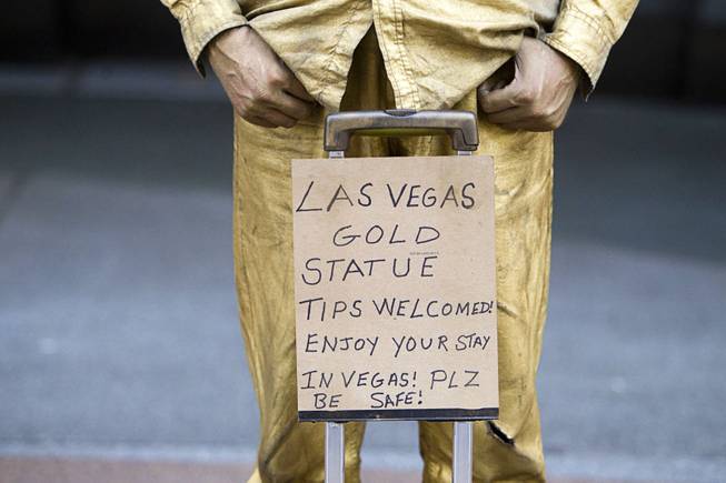 "Las Vegas Gold Statue" Steve McDonald stands behind a sign at Fremont Street Experience on Sunday, July 27, 2014, in downtown Las Vegas.