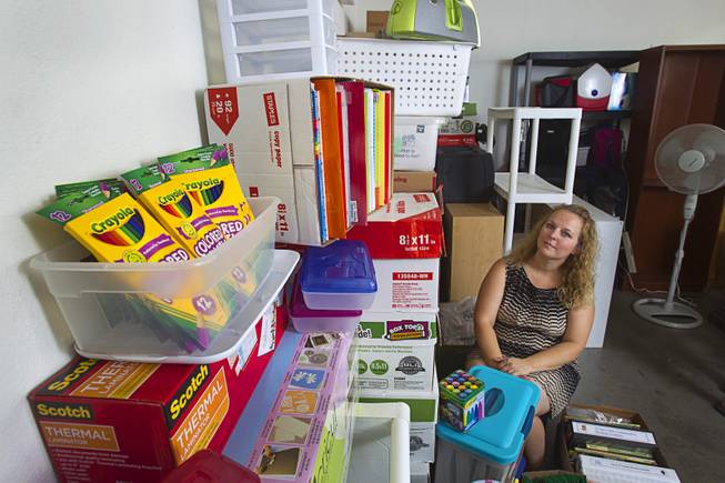 Kindergarten teacher Christine Cordova sits among school supplies stacked against a wall in the garage of her home in Henderson Sunday, July 27, 2014. Cordova rented a 19-foot U-Haul to pack up her classroom supplies from her old school as she prepares to move into a new school in the fall.