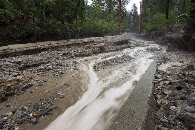 Storm runoff flows down Rainbow Canyon Boulevard in the Rainbow Subdivision on Mt. Charleston Monday, July 28, 2014. The neighborhood was hit hard by flooding and debris in runoff last year as well.