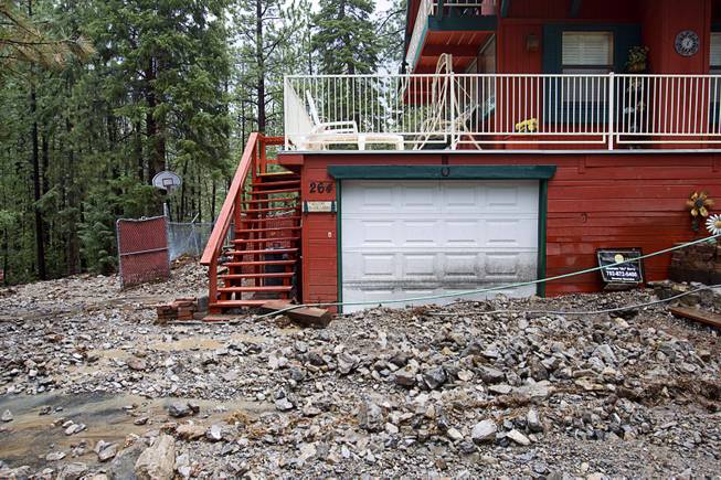 Debris is shown on front of a home in the Rainbow Subdivision on Mt. Charleston Monday, July 28, 2014. The neighborhood was hit hard by flooding and debris in runoff last year as well.
