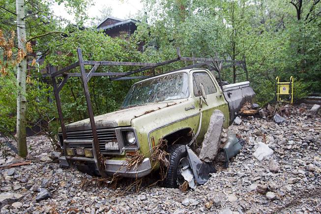 A truck is partially buried in debris at the Grismanauskas home in the Rainbow Subdivision on Mt. Charleston Monday, July 28, 2014. The neighborhood was hit hard by flooding and debris in runoff last year as well.