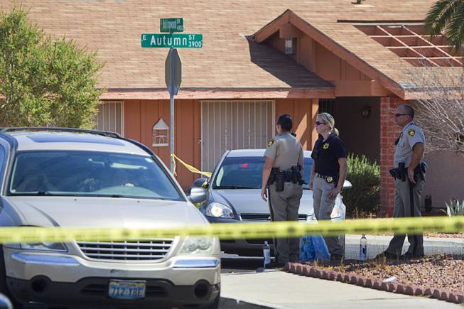 Metro Police officers are shown in a neighborhood near Tropicana Avenue and Sandhill Road after an officer-involved shooting Tuesday, July 29, 2014. The shooting was related to a home invasion, according to Metro Police.