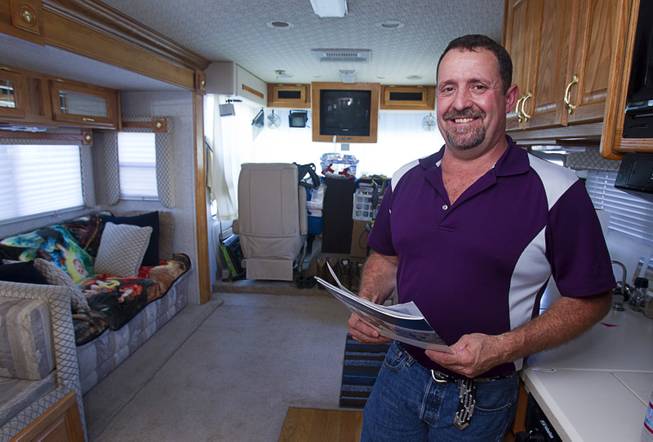 Cass Via, a maintenance worker at the High Roller, poses with a home listing inside his RV at the Oasis Las Vegas RV Resort Tuesday, July 29, 2014. Via is in the market for a house but says he will be buying a pre-owned home, not a new home.
