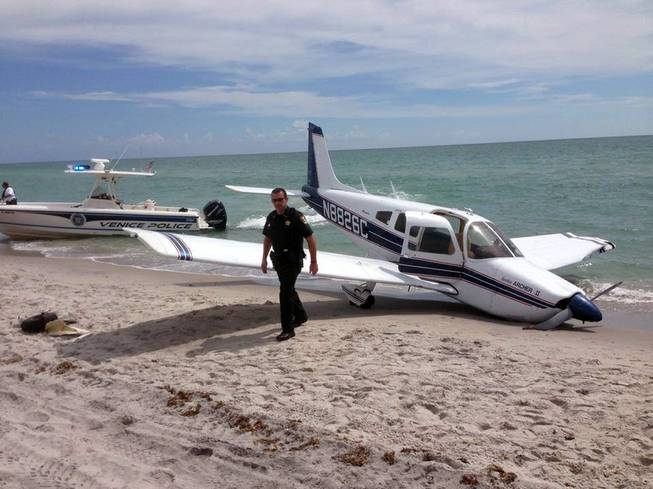 This Sunday, July 27, 2014, photo provided by the Sarasota County Sheriff's Office shows emergency personnel at the scene of a small plane crash in Caspersen Beach in Venice, Fla.