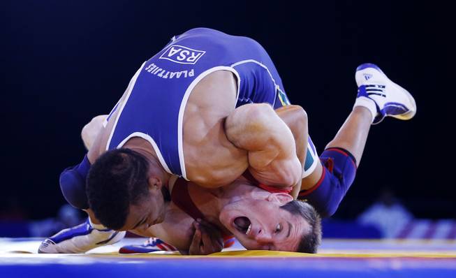 England's Sasha Madyarchyk, foreground, and South Africa's Marno Plaatjies challenge during the 61kg Repechage Wrestling at the Commonwealth Games 2014, in Glasgow, Wednesday July 30, 2014. 