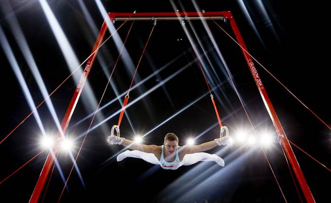 Lights flare as Harry Owen of Wales performs on the rings during the Men's All-Around gymnastics competition at the Scottish Exhibition Conference Centre during the Commonwealth Games 2014 in Glasgow, Scotland, Wednesday July 30, 2014. 