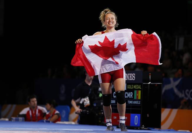 Gold medalist Dori Yeats of Canada celebrates waving the national flag of Canada after defeating Angele Tomo of Cameroon in their gold medal women's 69 kg wrestling bout at the Commonwealth Games Glasgow 2014, in Glasgow, Scotland, Wednesday, July, 30, 2014. 