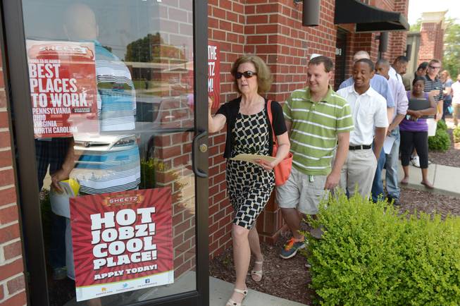 In this Wednesday, June 18, 2014, photo, job seekers attend a job fair held by Sheetz to staff their under-construction distribution center, in Burlington, N.C. As the economic recovery enters its sixth year, many Americans don't feel better off.