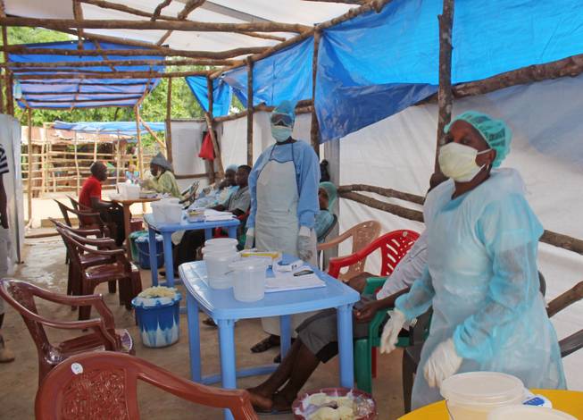 In this photo taken on Sunday, July 27, 2014, Medical personnel inside a clinic taking care of Ebola patients in the Kenema District on the outskirts of Kenema, Sierra Leone.
