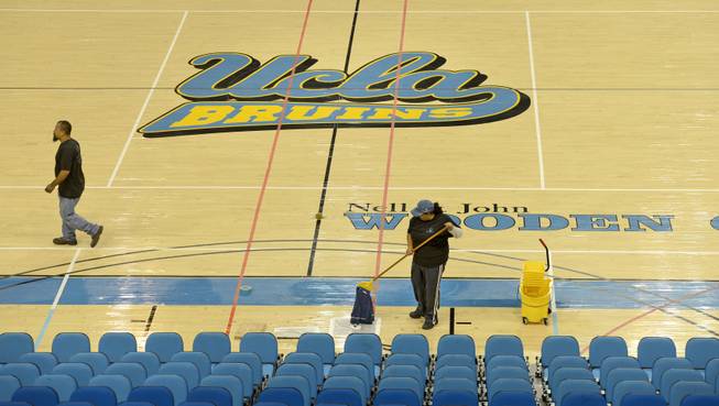 Cleaning crews work to dry the floor at UCLA's Pauley Pavilion on Wednesday, July 30, 2014, a day after a steel pipe burst along Sunset Boulevard and flooded parts of the campus and nearby streets.