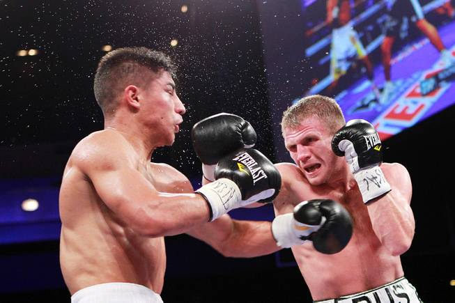 Jessie Vargas gets hit by Anton Novikov during their WBA light welterweight title fight Saturday, Aug. 2, 2014 at the Cosmopolitan. Vargas won by decision.