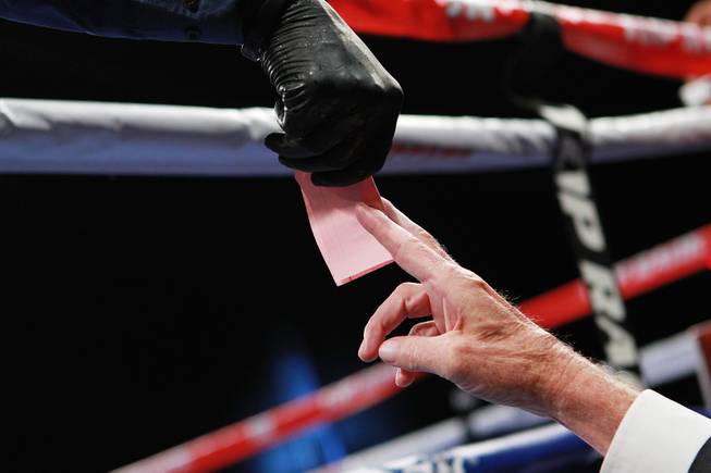 A judge hands a score sheet to referee Kenny Bayless during the Jessie Vargas vs. Anton Novikov WBA light welterweight title fight Saturday, Aug. 2, 2014 at the Cosmopolitan. Vargas won by decision.