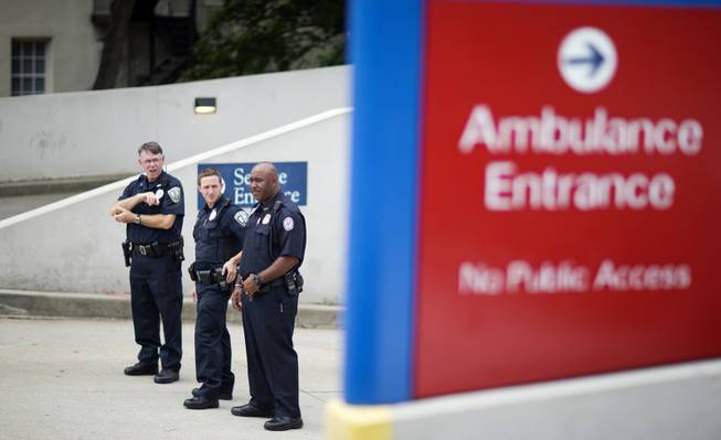 Police officers guard an entrance to Emory University Hospital after an ambulance arrived transporting an American that was infected with the Ebola virus Saturday, Aug. 2, 2014, in Atlanta. A specially outfitted plane carrying Dr. Kent Brantly from West Africa arrived at a military base in Georgia. Brantly was taken to the Atlanta hospital. Another American with Ebola is expected to join him at the hospital in a few days.
