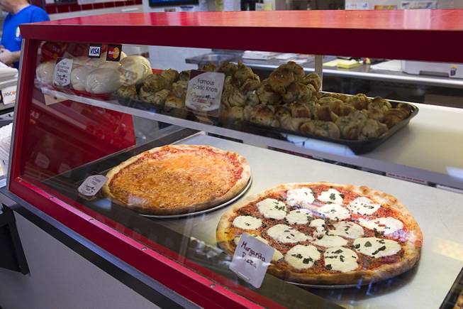 Pizza, garlic knots and fresh homemade Mozzarella cheese is shown in a display case at Cugino's Italian Deli and Pizzeria Sunday, Aug. 3, 2014.