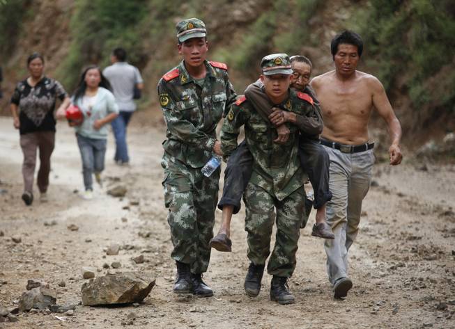 In this photo released by China's Xinhua News Agency, rescuers transport injured people after an earthquake in Zhaotong City in the densely populated Ludian county in southwest China's Yunnan Province, Sunday Aug. 3, 2014. The strong earthquake in southern China's Yunnan province toppled thousands of homes on Sunday, killing at least 175 people and injuring more than 1,400, according to China's official Xinhua News Agency. 