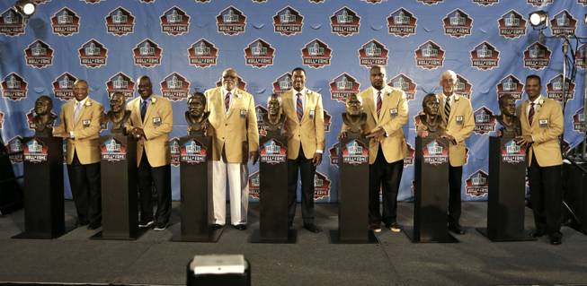 Inductees Aeneas Williams, Derrick Brooks, Claude Humphrey, Michael Strahan, Walter Jones, Ray Guy and Andre Reed, from left, pose with their busts at the Pro Football Hall of Fame enshrinement ceremony Saturday, Aug. 2, 2014, in Canton, Ohio.