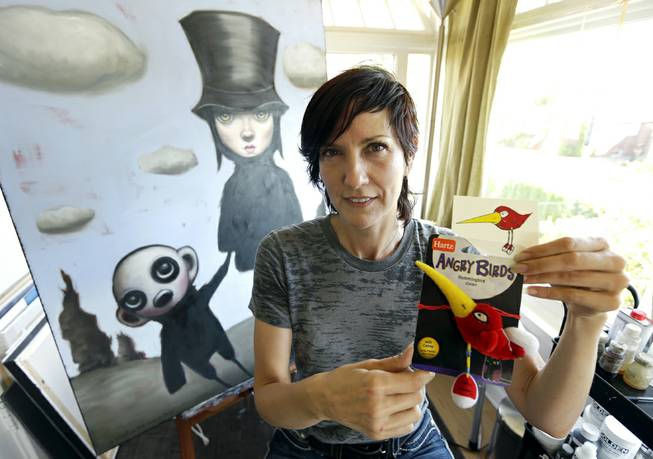 Artist Juli Adams on Tuesday, Aug. 5, 2014, in her home art studio in Seattle with one of her original drawings that a line of plush pet toys called "Angry Birds" was based. 