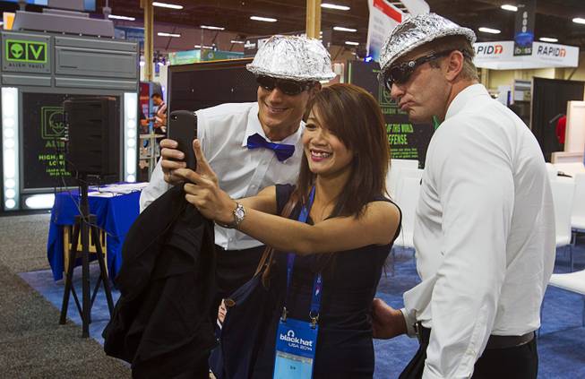 Quan Ngo, center, an information technology research analyst from Canada, takes a selfie with Rocky Fain, left, and John Cook at the Securonix booth during the Black Hat USA 2014 hacker conference at the Mandalay Bay Convention Center Aug. 6, 2014.