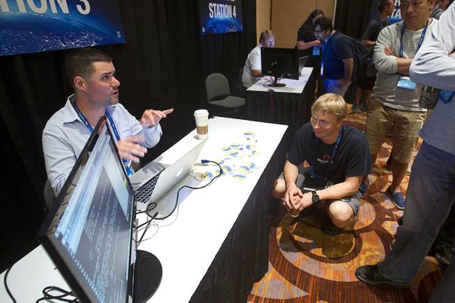 Raphael Mudge, left, of Strategic Cyber demonstrates Morning Catch software as Mait Peekman, a penetration tester from Estonia, looks on during the Black Hat USA 2014 hacker conference at the Mandalay Bay Convention Center Aug. 6, 2014. Morning Catch teaches non-technical people how to visualize phishing attacks, Mudge said.