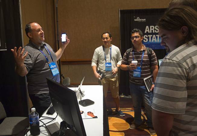 David Schwartzberg, left, a senior sales engineer at MobileIron, demonstrates the ZitMo Non web App prototype during the Black Hat USA 2014 hacker conference at the Mandalay Bay Convention Center Aug. 6, 2014. The App detects the Zitmo malware on Android devices. The malware can be used to steal numbers used in mobile financial transactions, Schwartzberg said.