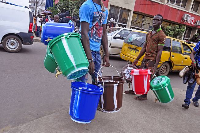 Water bucket sellers hawk their wares as the public buy them to try to protect them selves from the deadly Ebola virus in Monrovia, Liberia, Wednesday, Aug. 6, 2014. The price of buckets has increased as Liberian people are encouraged to wash their hands after filling it with disinfectant to prevent the spread of the deadly Ebola virus.