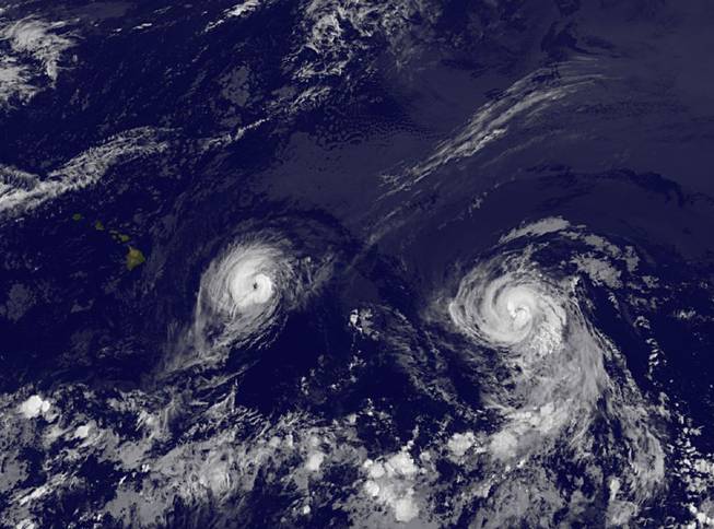 This image provided by NOAA taken Thursday Aug. 7, 2014, at 2 a.m. EDT shows Hurricane Iselle, left and Hurricane Julio.