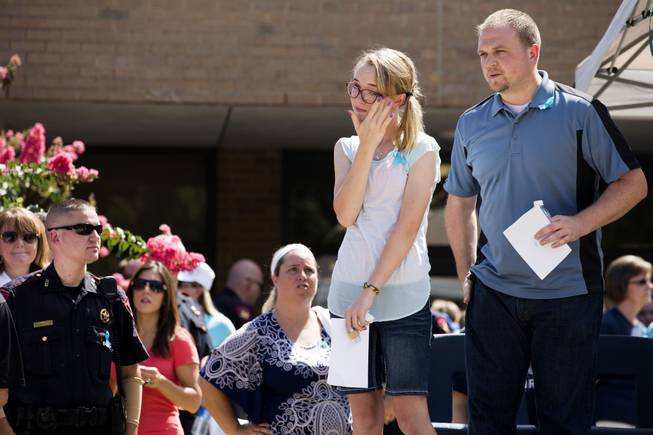 Cassidy Stay, second from right, the lone survivor of a family massacre in Texas, wipes her eye during a community memorial at Lemm Elementary School on Saturday, July 12, 2014, in Spring, Texas.