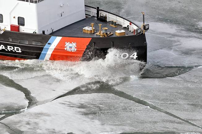 In this Tuesday, April 22, 2014, photo, the 140-foot icebreaker Biscayne Bay cuts through thick ice on the St. Mary's River on its way to escort vessels north to the Soo Locks, in Sault Ste. Marie, Mich. The U.S. Coast Guard spent more than four months breaking ice to open shipping lanes throughout the Great Lakes. Canada has sent two icebreakers to the High Arctic to gather scientific data in support of its plan to bid for control of the sea floor under and beyond the North Pole.