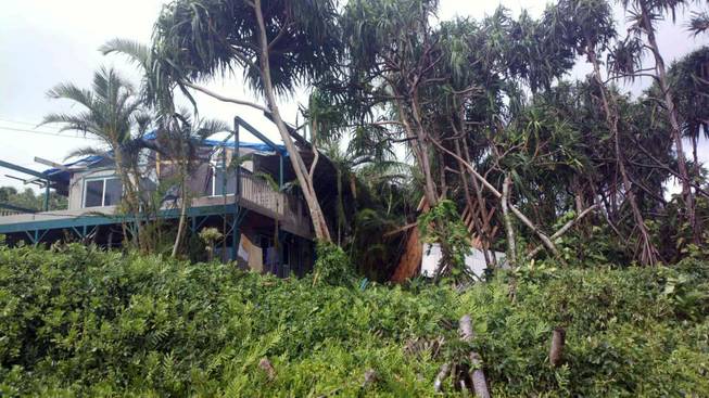 This photo provided by Andrew Fujimura shows the damage from Tropical Storm Iselle on a home in Puna, Hawaii, on Saturday, Aug. 9, 2014. Tropical Storm Iselle, knocked down trees, battered roofs and left the isolated area without electricity.