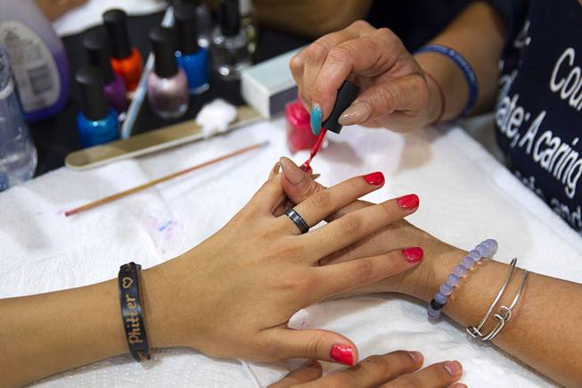 A girl has her nails done during a special back-to-school event for foster children at Square Salon, 1225 South Fort Apache Blvd., during a Sunday, August 10, 2014. The event was sponsored by the CASA Foundation, a local non-profit organization, in partnership with Square Salon and other organizations.