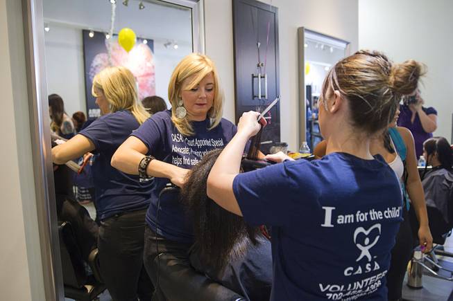 Stylists Laura Stewart, left, and Jodi Lee work on a girl's hair during a special back-to-school event for foster children at Square Salon, 1225 South Fort Apache Blvd., during a Sunday, August 10, 2014. The event was sponsored by the CASA Foundation, a local non-profit organization, in partnership with Square Salon and other organizations.