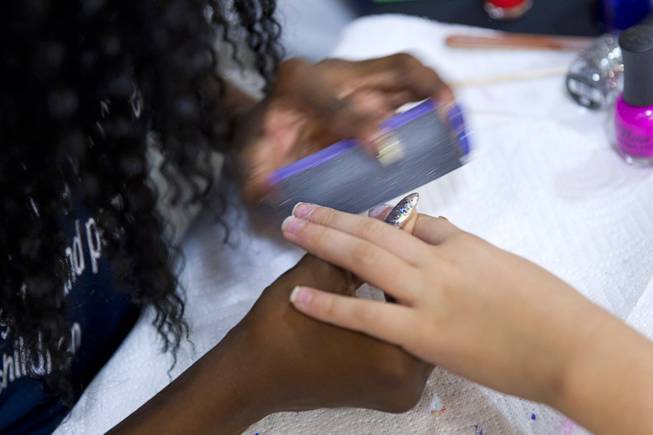 A girl has her nails buffed during a special back-to-school event for foster children at Square Salon, 1225 South Fort Apache Blvd., during a Sunday, August 10, 2014. The event was sponsored by the CASA Foundation, a local non-profit organization, in partnership with Square Salon and other organizations.