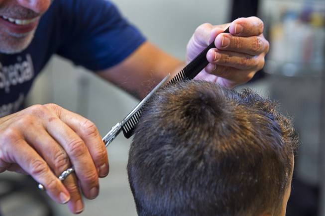 A boy has his hair cut during a special back-to-school event for foster children at Square Salon, 1225 South Fort Apache Blvd., during a Sunday, August 10, 2014. The event was sponsored by the CASA Foundation, a local non-profit organization, in partnership with Square Salon and other organizations.