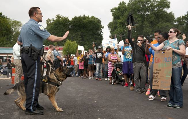 Protestors confront police during an impromptu rally, Sunday, Aug. 10, 2014, to protest the shooting of Michael Brown, 18, by police in Ferguson, Mo. Saturday, Aug. 9, 2014. Brown died following a confrontation with police, according to St. Louis County Police Chief Jon Belmar, who spoke at a news conference Sunday.
