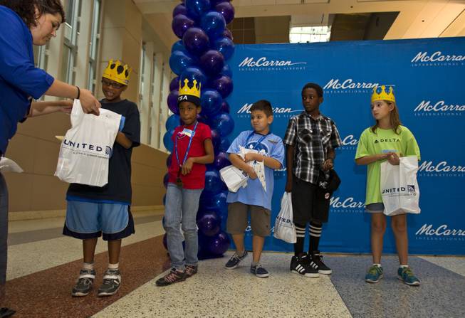 Children from the Boys & Girls Clubs of Southern Nevada receive prizes for placing during the Paper Plane Palooza competition at McCarran International Airport on Tuesday, August 12, 2014.