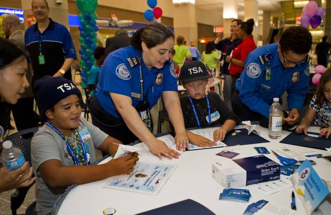 The team from the TSA work together to fold their airplanes before the Paper Plane Palooza competition begins at McCarran International Airport on Tuesday, August 12, 2014.