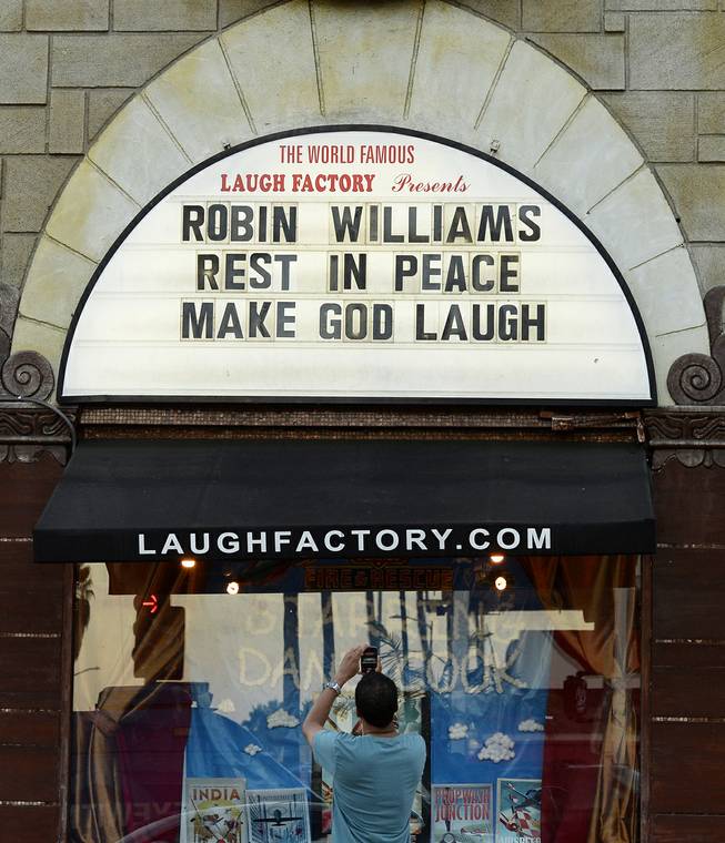 A man takes a photo of a the marquee of the Laugh Factory with a message in memory of actor Robin Williams displayed, in the Hollywood district of Los Angeles Monday, Aug. 11, 2014. Williams, the Academy Award winner and comic supernova whose explosions of pop culture riffs and impressions dazzled audiences for decades died Monday in an apparent suicide at his San Francisco Bay area home. He was 63. 