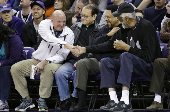 In this Jan. 25, 2014, photo, then-Microsoft CEO Steve Ballmer, left, shakes hands with former NBA players Bill Russell, right, and "Downtown" Freddie Brown as Omar Lee looks on during an NCAA basketball game between Washington and Oregon State in Seattle. Ballmer is officially the new owner of the Los Angeles Clippers. The team says the sale closed Tuesday, Aug. 12, 2014, after a California court confirmed the authority of Shelly Sterling, on behalf of the Sterling Family Trust, to sell the franchise.