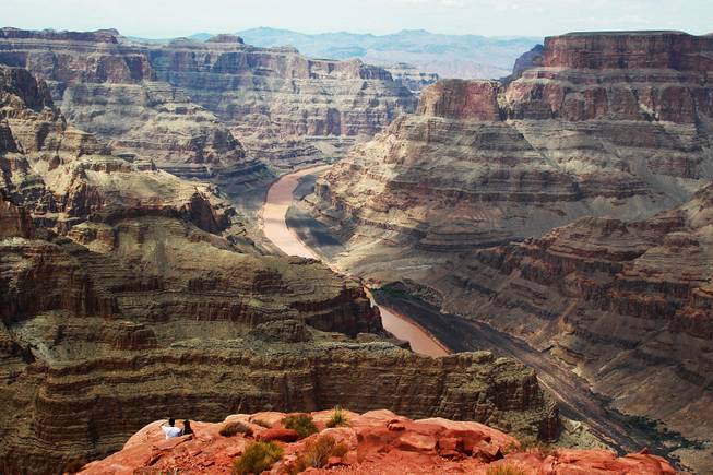A couple takes in the view of the Colorado River as it runs through the Grand Canyon at Grand Canyon West Tuesday, Aug. 12, 2014.