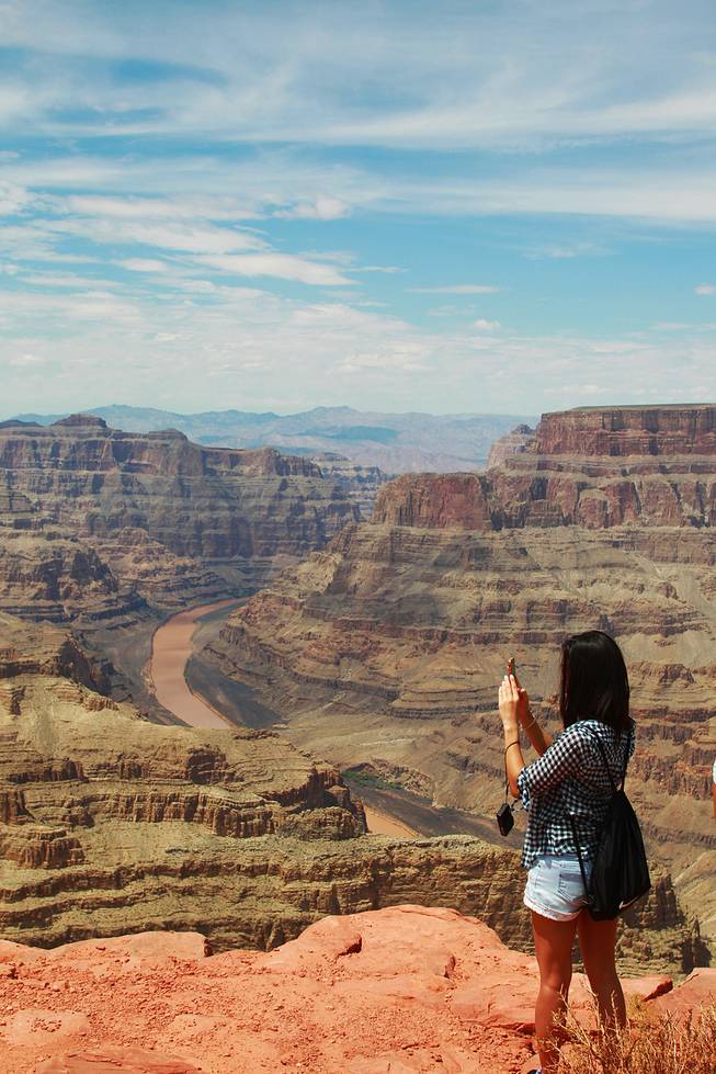 A tourist takes in the view at Grand Canyon West Tuesday, Aug. 12, 2014.