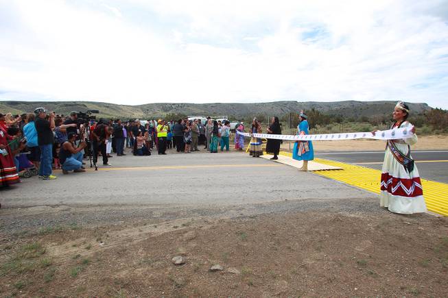 A ribbon is prepared to be cut during the official opening of the newly paved section of Diamond Bar Road leading to Grand Canyon West Tuesday, Tuesday, Aug. 12, 2014.