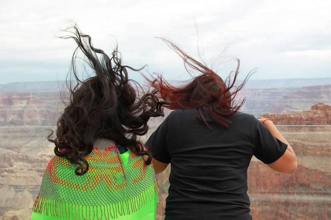 The hair of Joyce Paya, left, and Deshay Benson is blow up from a breeze on the Skywalk after the official opening of the newly paved section of Diamond Bar Road leading to Grand Canyon West Tuesday, Tuesday, Aug. 12, 2014.