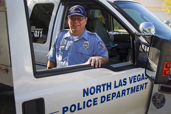 North Las Vegas Animal Control officer Dale Smock poses at his truck by a home in North Las Vegas Thursday Aug. 14, 2014. Smock recently helped clear the house of over 100 cats. The house has since been condemned.