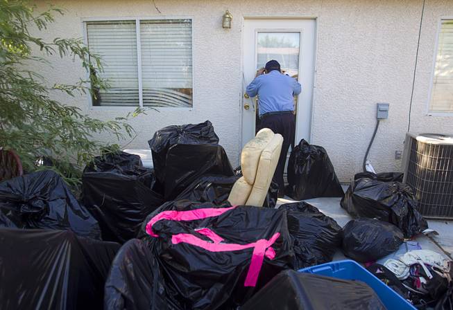 North Las Vegas Animal Control officer Dale Smock looks into the back door of a home in North Las Vegas Thursday Aug. 14, 2014. Smock recently helped clear a house of over 100 cats. The house has since been condemned.